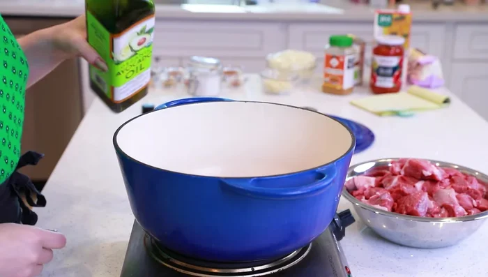 Rosolare l'agnello da tutte le parti in una pentola grande a fuoco medio-alto con un filo di olio di avocado.