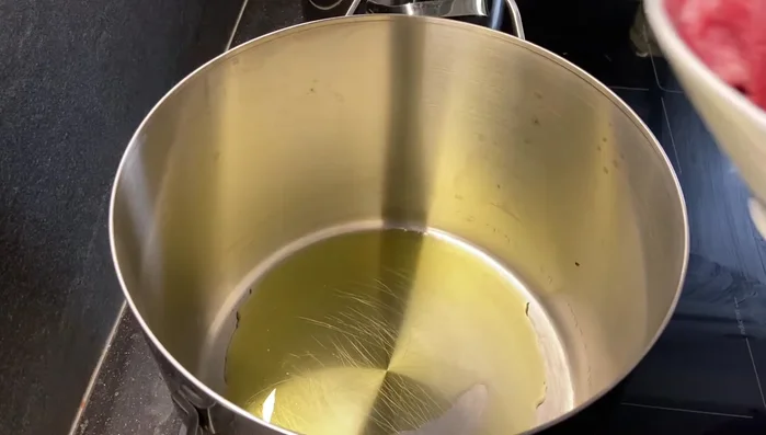 In una pentola, aggiungere un po' di olio e rosolare il manzo fino a doratura. Togliere la carne dalla pentola e metterla da parte.