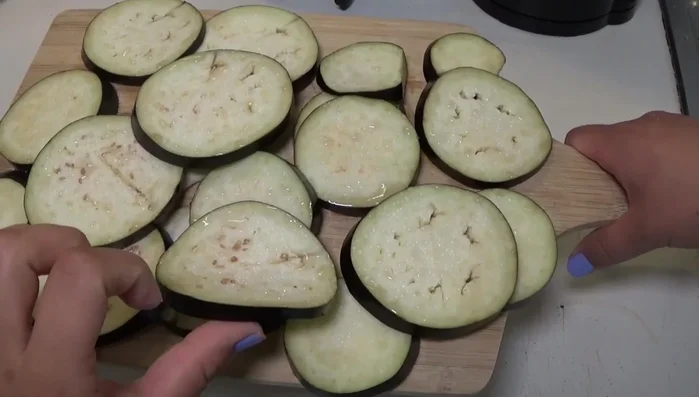 Tagliare le melanzane a fette, salarle per farle sgrondare, poi asciugarle bene e friggerle.
