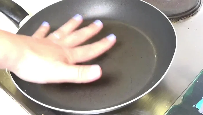 Stendere l'impasto per la pizza. Riscaldare una padella antiaderente e cuocere la base della pizza brevemente prima di aggiungere il pomodoro condito con aglio, basilico, origano, sale, pepe e olio.