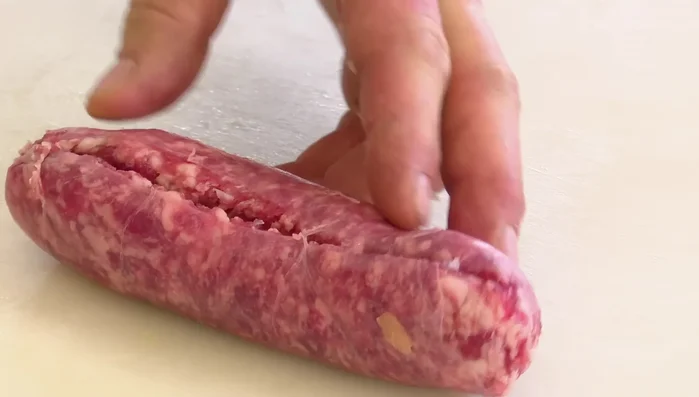 Togliere la pelle alla salsiccia e sbriciolarla.