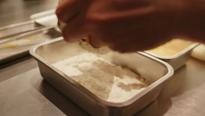 Impanare il pane: farina, uovo sbattuto, pancarrè passato al setaccio (287.4). Assicurarsi che il pancarrè aderisca bene, creando una panatura non troppo spessa (293.52).