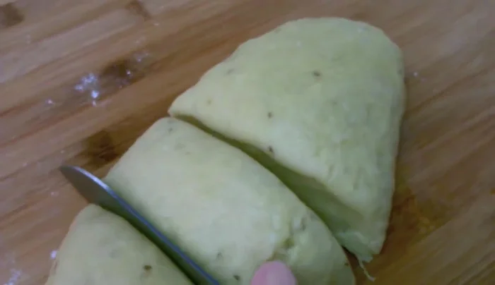 Dividiamo l'impasto in più parti, ricavando tanti piccoli pezzi più o meno regolari. Stendiamo ogni pezzetto, facendolo scivolare sotto le mani, formando un cordoncino.