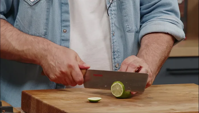 Tagliare finemente delle fette di lime per la guarnizione.