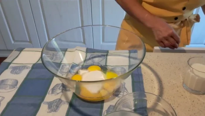 Preparare la crema pasticcera: In una ciotola, sbattere le uova con lo zucchero. Aggiungere la farina setacciata e un bicchiere di latte, mescolando per evitare grumi.