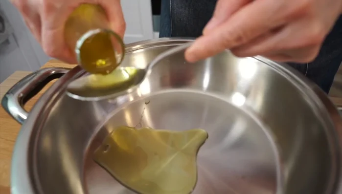 Mettere l'olio in una pentola e aggiungere l'aglio. Cuocere a fiamma medio-alta.