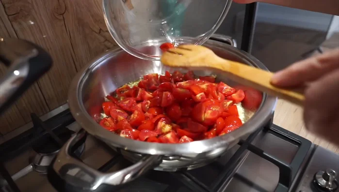 Appena l'aglio imbiondisce, aggiungere i pomodori e farli insaporire. Aggiungere sale.