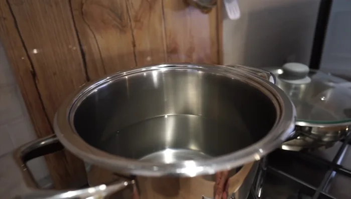 Mettere un tegame sul fuoco per bollire i fagiolini. Aggiungere acqua e accendere la fiamma. (Pulizia dei fagiolini)