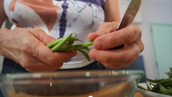 Raggruppare i fagiolini e tagliare le estremità. Lavare e mettere in acqua con bicarbonato.