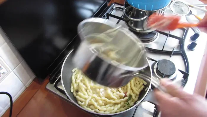 Aggiungere la crema di pecorino e mescolare fino a ottenere una consistenza cremosa. Se necessario, aggiungere un po' di acqua di cottura della pasta.