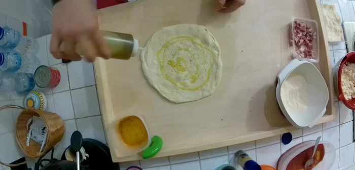 Condire la base della pizza con olio d'oliva, pepe nero macinato fresco.
