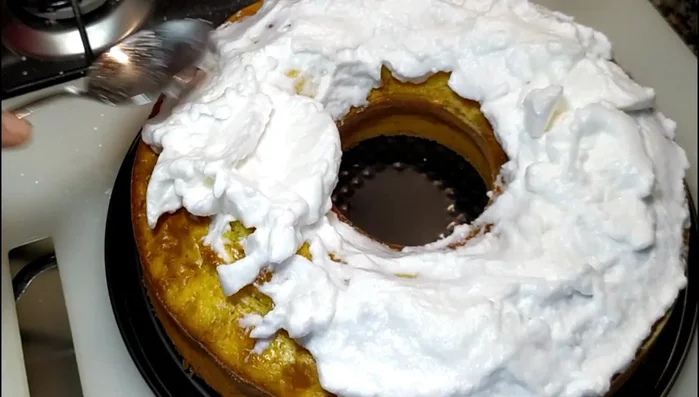 Ricopri la torta con gli albumi montati e passa sotto il grill del forno a 180° per circa 10 minuti, per dorare gli albumi.