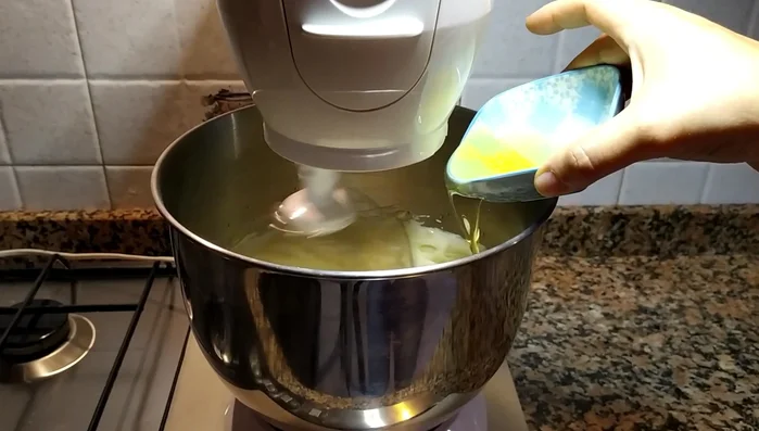 Aggiungi 75 g di olio di semi, il succo di un limone e di un'arancia. Mescola.