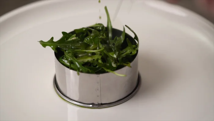 Impiattare la tagliata su un letto di rucola, con grana padano e olio infuso alla rucola. (491.78)