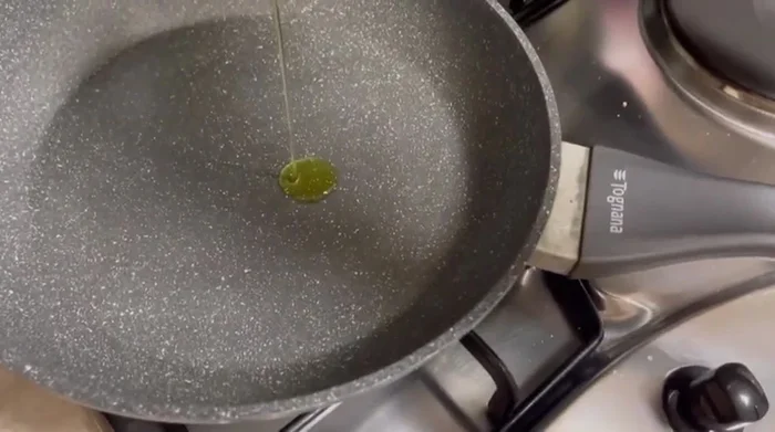 In una padella, aggiungere un filo d'olio e uno spicchio d'aglio. Accendere la fiamma e riscaldare.