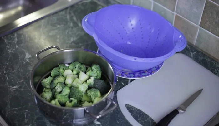 Una volta che l'acqua bolle, mettiamo il cestello con i broccoli nella pentola. Lasciamo cuocere per circa 10-15 minuti.