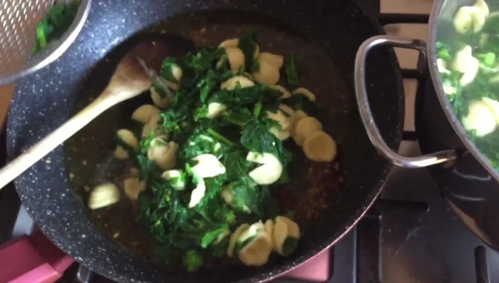 Aggiungete la pasta e le cime di rapa al tegame con l'aglio, l'olio, il peperoncino e le acciughe.