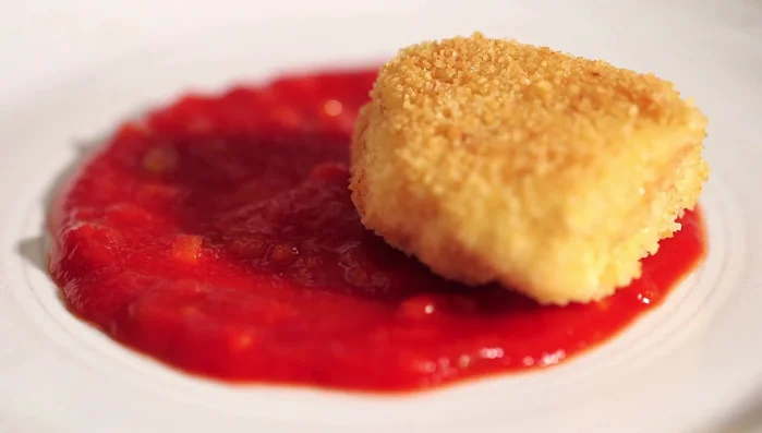 Impiattare: disporre il sugo sul piatto, aggiungere i cubotti di pollo fritti e guarnire con qualche fogliolina di basilico fresco.