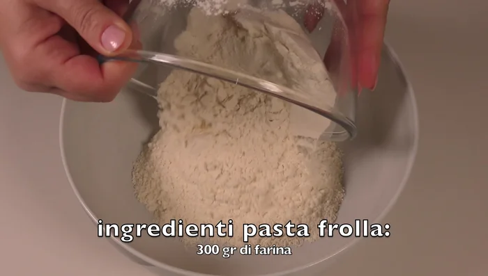 Preparare la pasta frolla: in una ciotola, mettere 300g di farina, 110g di burro freddo a tocchetti, un pizzico di sale. Lavorare con le dita fino ad ottenere un composto sabbioso. (137.87)