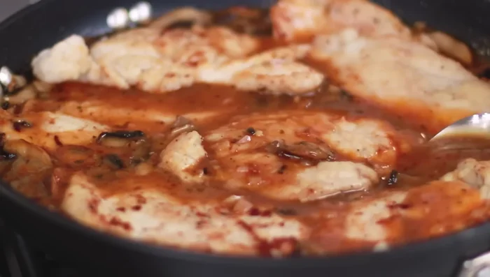Aggiungere il pollo cotto alla salsa e condire con prezzemolo fresco.