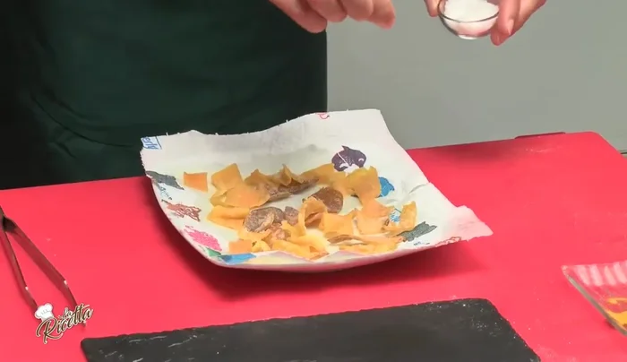 Salare le chips di zucca a piacere, appena sfornate.