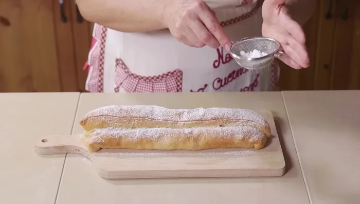 Arrotolare la pasta sfoglia formando uno strudel.