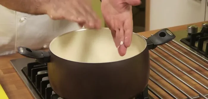 In una casseruola dai bordi alti, aggiungere olio, il battuto di verdure, uno spicchio d'aglio intero e un peperoncino. Far soffriggere bene.