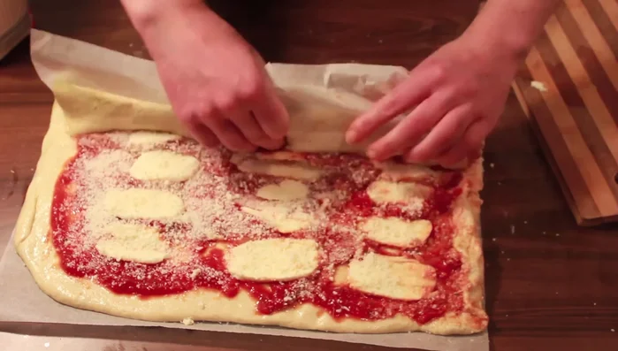 Arrotolare l'impasto aiutandosi con la carta forno. Tagliare a fette. [262.449]