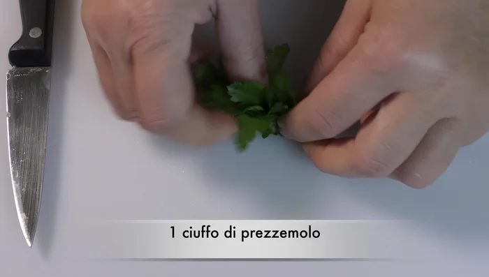 Nel frattempo, tritare finemente aglio, peperoncino e prezzemolo.