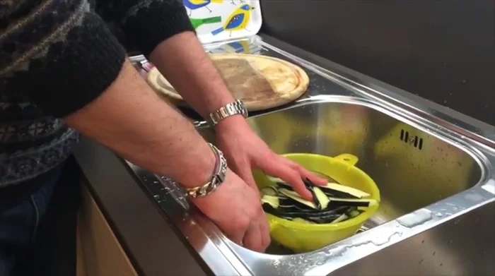 Sciacquare le melanzane sotto acqua fredda per rimuovere il sale in eccesso e strizzarle bene per eliminare tutta l'acqua.