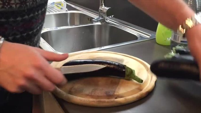 Lavare le melanzane e affettarle sottilmente (3-4 mm di spessore). Assicurarsi di uno spessore costante per una cottura uniforme.