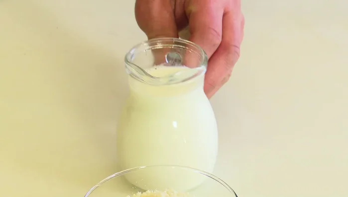Versare il latte tiepido a filo, mescolando continuamente per evitare grumi.
