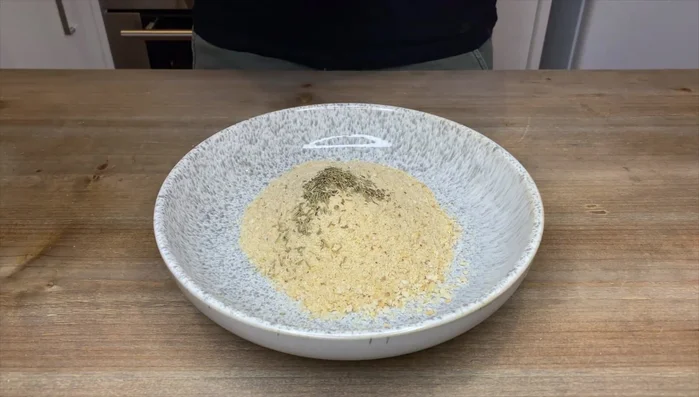 Mescolare il pangrattato con origano, timo, basilico, rosmarino, aglio in polvere, sale e pepe.