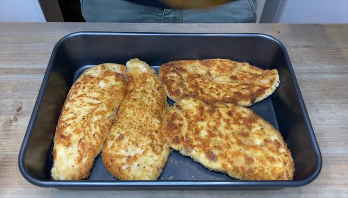 Disporre il pollo in una teglia, versare sopra la salsa marinara, parmigiano e mozzarella.