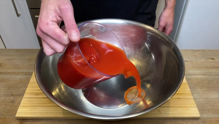 Aggiungere 800g di pomodori interi nel loro succo e 125ml di acqua alle lattine per rilasciare il succo.