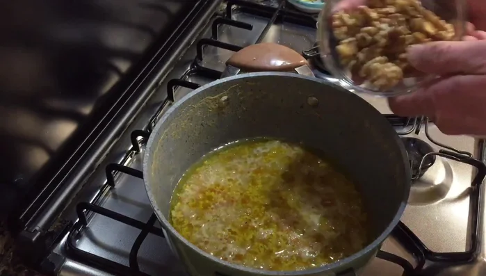 Nel tegame, aggiungere le noci e farle insaporire nel fondo di cottura.