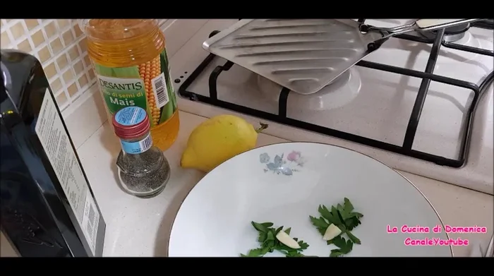 Tritare finemente prezzemolo, aglio. Spremere il succo di un limone.