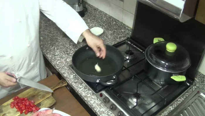 In una padella, mettiamo un filo d'olio extravergine di oliva e uno spicchio d'aglio in camicia (con la buccia).