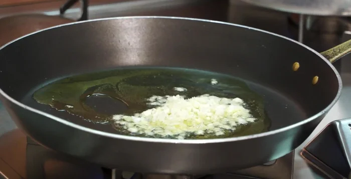 Soffriggere il trito: in una padella, soffriggere leggermente il trito con aglio e un po' di peperoncino.