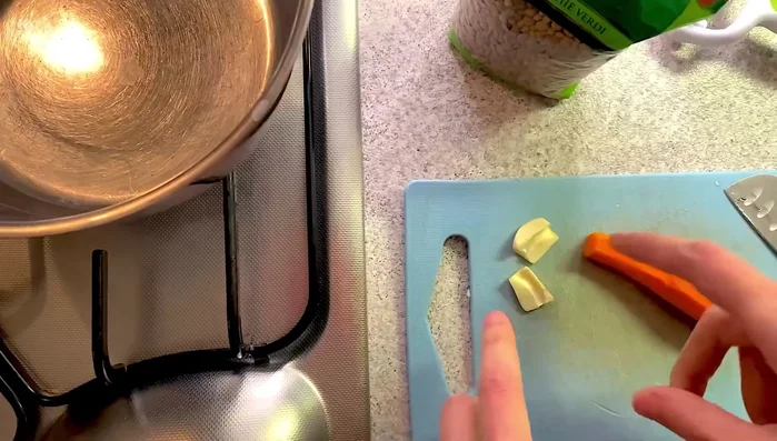 Lavare e pulire una carota e uno spicchio d'aglio, togliendo l'anima all'aglio.