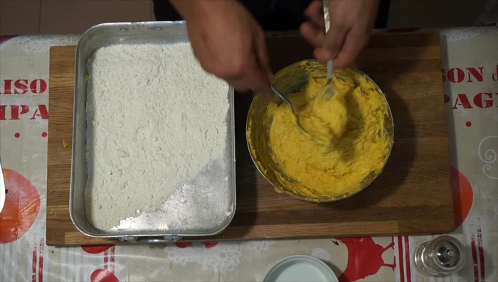Infarinate una superficie di lavoro. Prendete porzioni di impasto e formate delle palline usando un cucchiaio, quindi rotolatele nella farina.