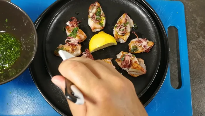 Spennellate i calamari con l'olio aromatizzato al prezzemolo.