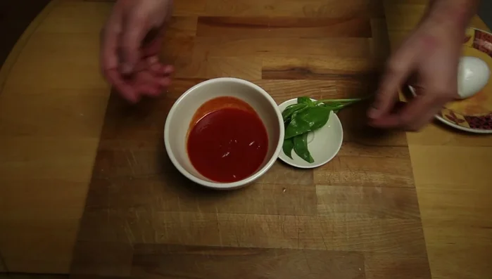 Preparare la salsa di pomodoro: mescolare la passata (o polpa) di pomodoro con un pizzico di sale e mezza cipolla (da rimuovere poi). Aggiungere le foglie di basilico fresco e lasciare riposare.