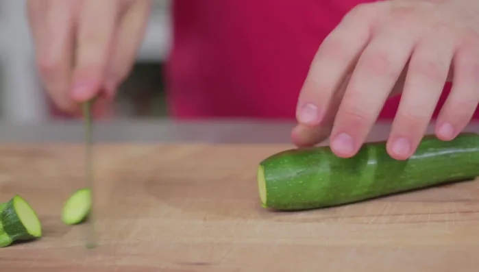 Tagliare le zucchine a bastoncino. Eliminare le estremità e, a seconda della grandezza, tagliarle in due o tre parti. Appoggiare sul tagliere per un taglio preciso.