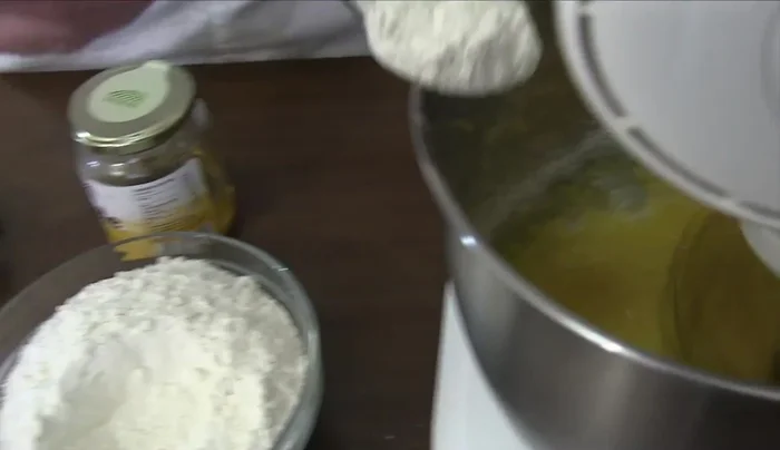 Aggiungere miele, sale, lievito setacciato insieme ad un terzo della farina (200.08).