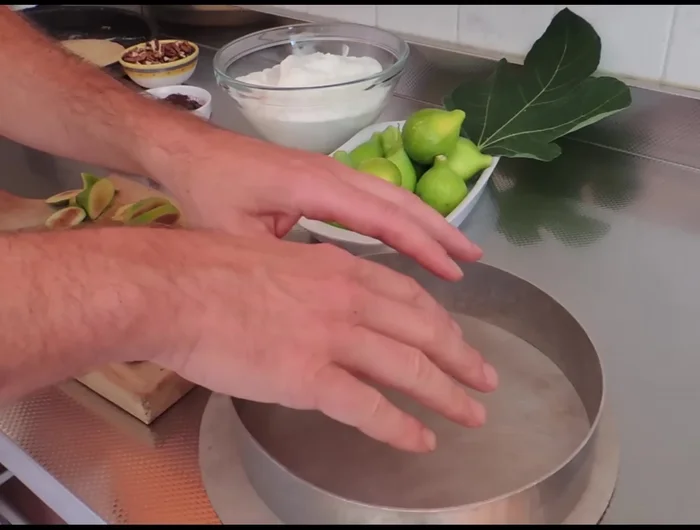 Disporre le fette di fichi all'interno del cerchio per dolci, creando il primo strato della torta. Se necessario, aggiungere fette anche ai bordi.