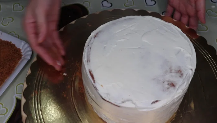 Decora la torta con i biscotti tritati, creando ciuffetti di crema e decorando con triangoli di biscotto (966.31).