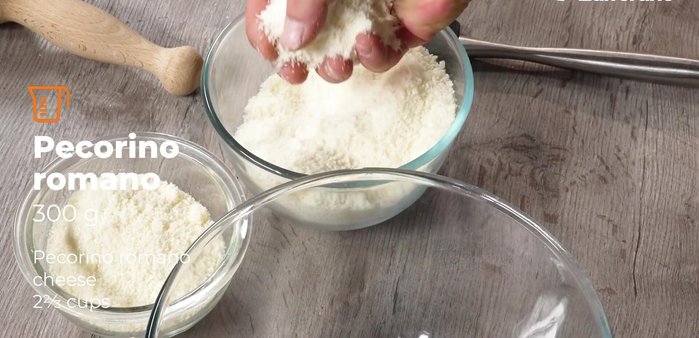 Preparare il condimento: grattugiare il pecorino romano e aggiungere una piccola quantità di parmigiano reggiano per mitigare la sapidità del pecorino. Aggiungere il pepe pestato.
