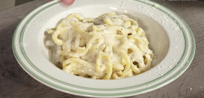 Servire i tonnarelli cacio e pepe, spolverando con pecorino romano e pepe tostato.