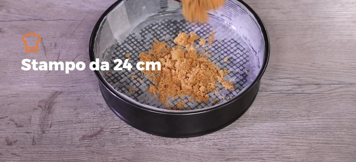 Trasferire il composto in uno stampo foderato con carta forno e pressarlo bene per formare la base.